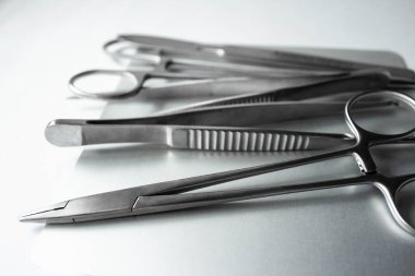 Metal tepside cerrahi aletler. Neşter, klemp, makas, beyaz arka planda cerrahi forseps. Tıbbi araçlar