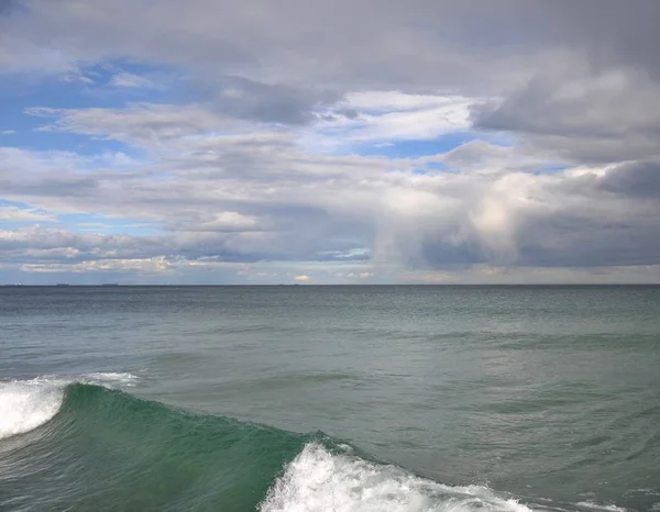 Klarblå Himmel Syns Genom Gråa Molnen Havet Förgrunden Grön Våg — Stockfoto
