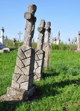 Terk edilmiş bir mezarlıkta anıtlar. Haç. 