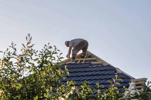 Roofer posa di piastrelle. Il padrone copre il tetto della casa con arguzia — Foto Stock