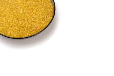 Beyaz arka planda kahverengi cam bir plaka içinde bulgur..