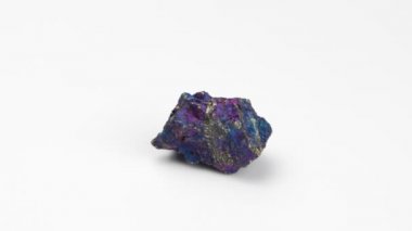 Beyaz arka planda mineral tebeşir ayini. Döndürme. Bakır piriti. Çok renkli doğal bir taş. Nugget yakın çekim görüntüsü. Mücevher..