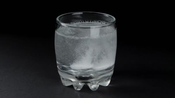 Deux comprimés effervescents dissous dans un verre d'eau. Fond noir. — Video