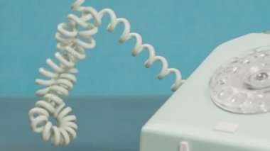 El, eski telefonun kablosunu çözer. Alıcı kapalı. Yakın plan. Yavaş çekim.