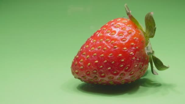 Gros plan sur les fraises. Fruits biologiques mûrs. Berry sur fond vert. Vidéo 4K. — Video