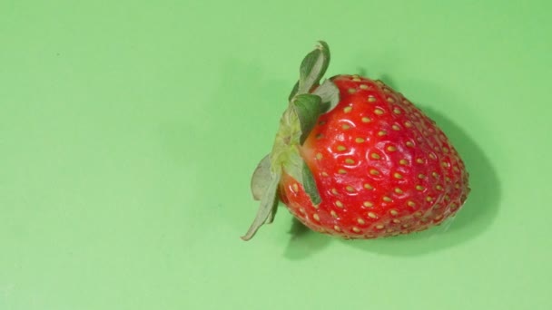Strawberry close-up. Ripe berry. 4K video. Green background. — Stock Video