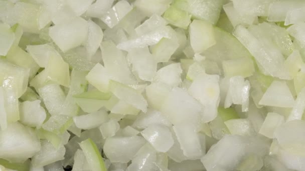 Cebolla cruda en rodajas. La cebolla se desmenuza en pequeños cubos. El ingrediente es el primer plano. — Vídeos de Stock