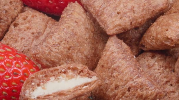 Delicious dry breakfast. Chocolate pillows with stuffing and fresh strawberries close-up. — Stock Video