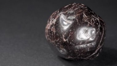 Karanlık bir arka planda mineral taşından yapılmış yakın plan. Bir parça taş nar..