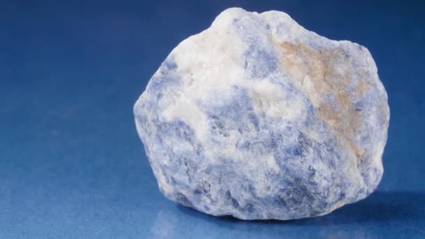 El mineral será salado sobre un fondo azul. Piedra decorativa y ornamental. Una pepita de visión de cerca. — Vídeos de Stock