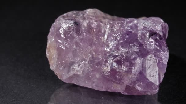 Amethist op een donkere achtergrond close-up. Natuursteen, mineraal van paarse kleur. — Stockvideo