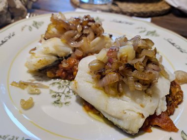 Baharatlı domates sosu üzerine karamelize arpacık soğanı kaplı morina balıklı morina balığı