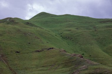 Mavi gökyüzü olan dağ manzarası. Yeşil tepelerin panoramik manzarası.