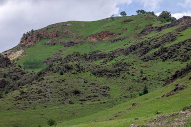 Mavi gökyüzü olan dağ manzarası. Yeşil tepelerin panoramik manzarası.