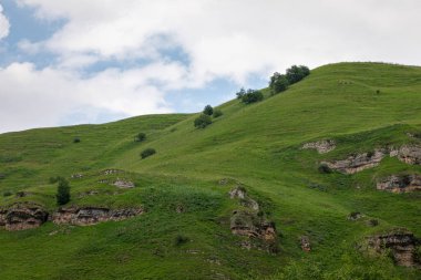 Mavi gökyüzü olan dağ manzarası. Yeşil tepelerin panoramik manzarası.