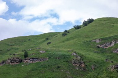 Mavi gökyüzü olan dağ manzarası. Yeşil tepelerin panoramik manzarası.