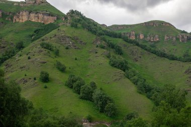 Mavi gökyüzü olan dağ manzarası. Yeşil tepelerin panoramik manzarası.