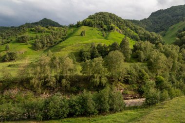 Mavi gökyüzü olan dağ manzarası. Yeşil tepelerin panoramik manzarası.