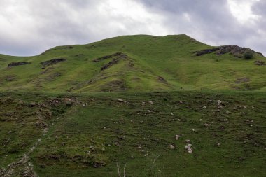 Mavi gökyüzü olan dağ manzarası. Yeşil tepelerin panoramik manzarası.
