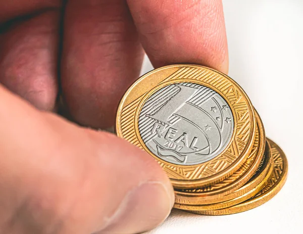 Real currency, money from Brazil. Man holds Real coins