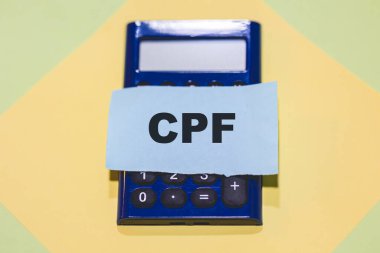 Ekranında bir kağıt parçasına CPF yazan hesap makinesi