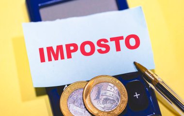 Brezilya gerçek sikkeleri, kalem, hesap makinesi ve IMPOSTO metni ile not