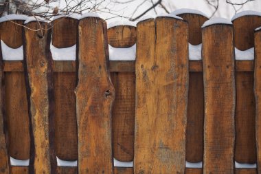 Kışın ahşap çiti kaplayan kar