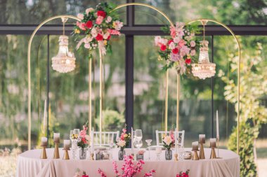 Zarif çiçek süslemesi, güneşli bir öğleden sonra güneşli bir bahçede romantik bir düğün masası kurulmasını sağlar.