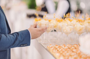Elegant gathering at a rooftop event featuring delicious desserts and refreshing drinks during a bright sunny afternoon