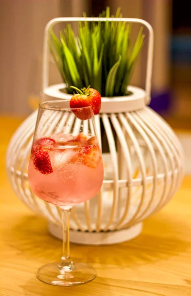 Refreshing summer drink pink Gin and Tonic with ice and Strawber