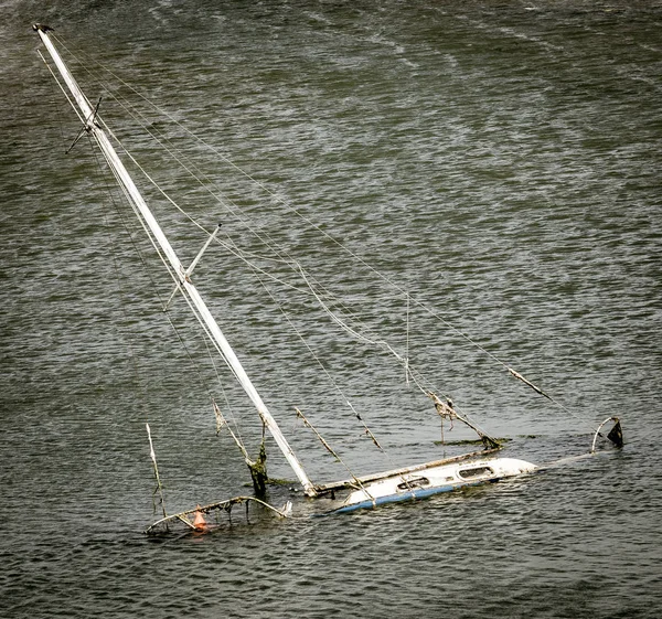 Sinking sunken sailing boat in rough water