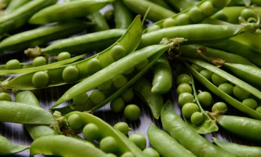 Fasulye koyu ahşap arka plan üzerinde izole taze yeşil bezelye pod. Eski bir rustik ahşap yüzey, yumuşak odak izole yeşil bezelye yatay kompozisyon Taze bakla