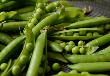 Fasulye koyu ahşap arka plan üzerinde izole taze yeşil bezelye pod. Eski bir rustik ahşap yüzey, yumuşak odak izole yeşil bezelye yatay kompozisyon Taze bakla