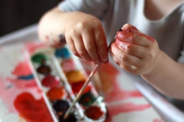 fotoğraf çocuk boya kirli elleri ile fırça dokunur. aga