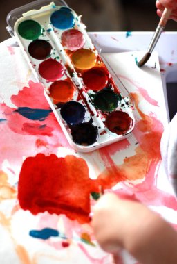 fotoğraf çocuk suluboya bal boyaları ile bir fırça boyar. küçük h