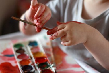 fotoğraf çocuk boya kirli elleri ile fırça dokunur. aga