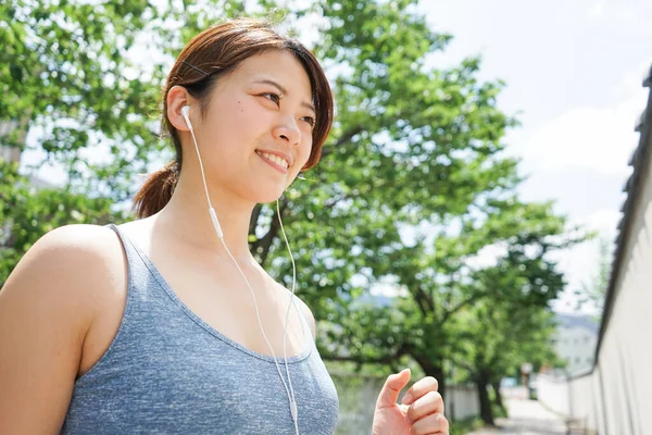 Mujer Joven Corriendo Escuchando Música —  Fotos de Stock