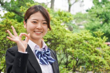 Öğrenci gülümseyerek ellerini sallıyor.