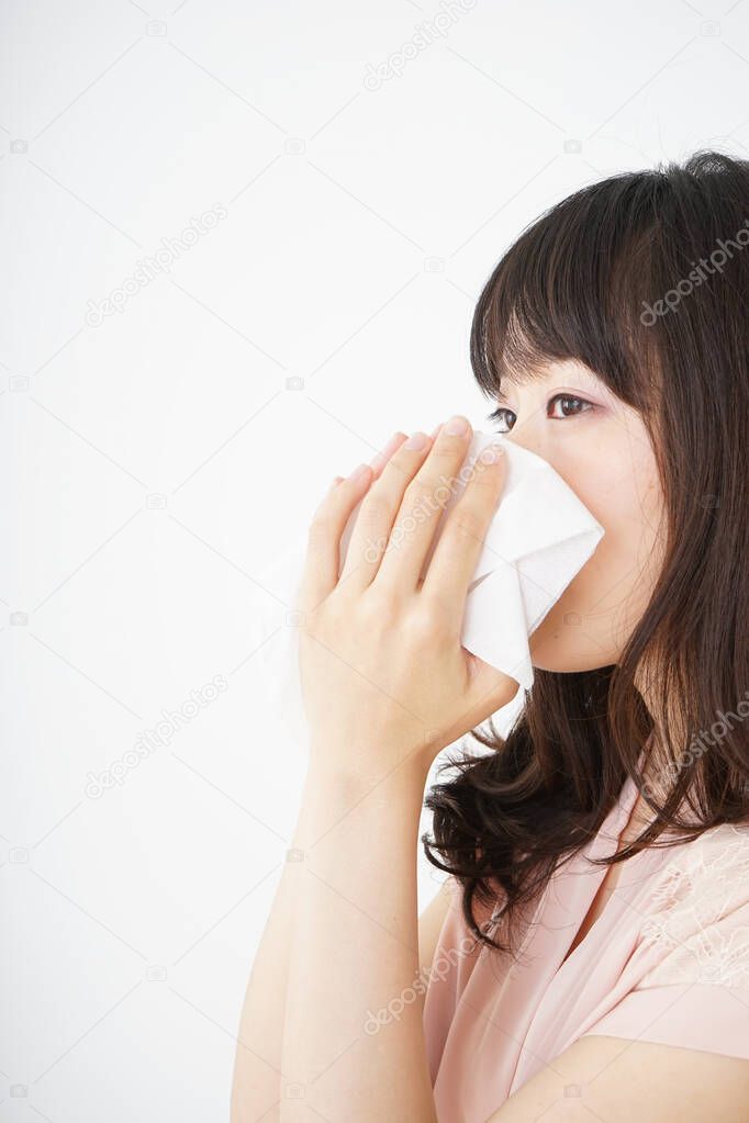 Young woman blowing her nose