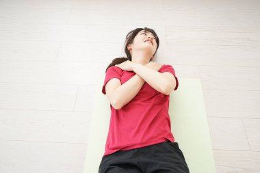 Genç bir kadın kas antrenmanı yapıyor.