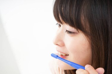  Genç bir kadın dişlerini fırçalıyor.