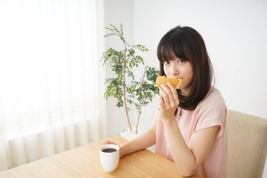 Genç bayan kahvaltı yapıyor.