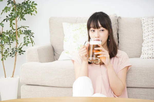 Молодая Азиатка Пьет Пиво Дома — стоковое фото