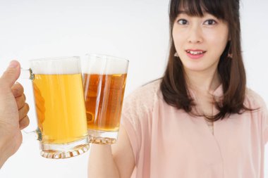 Genç Asyalı kadın evde bira içiyor.