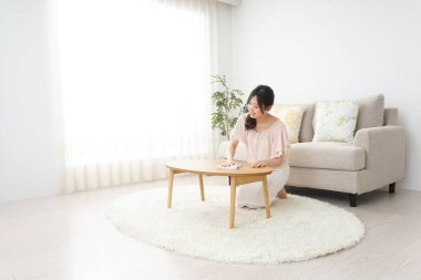 Genç Asyalı kadın masayı temizliyor. 