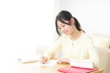 Evde okuyan genç bir kadın.