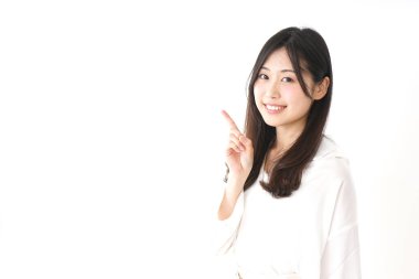 Güzel genç bir kadın bir şeyi işaret ediyor.