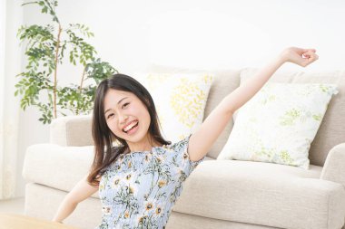 Kanepenin yanında oturan genç bir kadın.