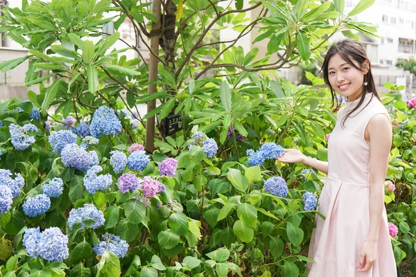 若いですアジアの女性ポージングとともに植物屋外 — ストック写真
