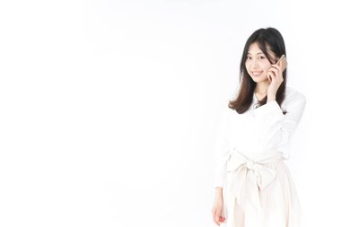 Genç Asyalı kadın telefonda konuşuyor.